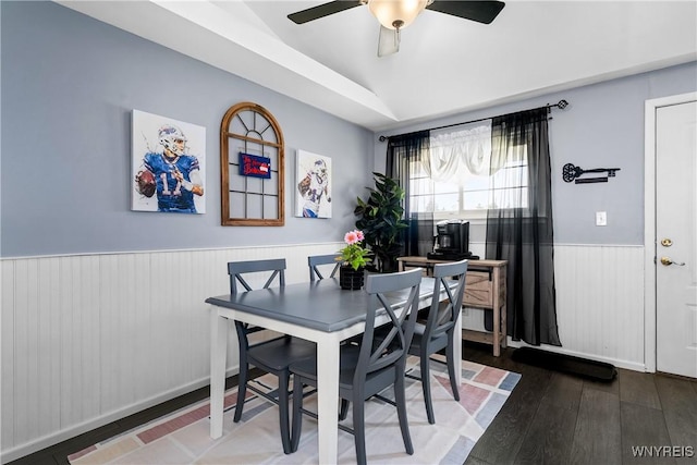 dining space with a wainscoted wall, wood finished floors, ceiling fan, and lofted ceiling