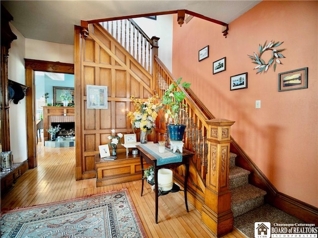 10412 Main St, Mina, NY 14736 - stairway featuring wood-type flooring and a brick fireplace