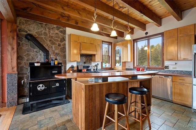 463 Hughes Rd, Russia, NY 13438 - kitchen featuring wooden ceiling, appliances with stainless steel finishes, stone tile flooring, a wood stove, and a center island