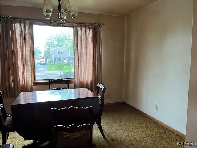 dining area with a chandelier, carpet flooring, and baseboards