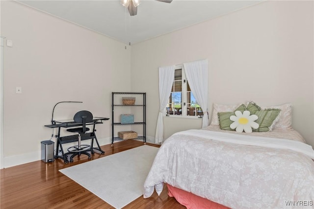 bedroom featuring wood finished floors, baseboards, and ceiling fan