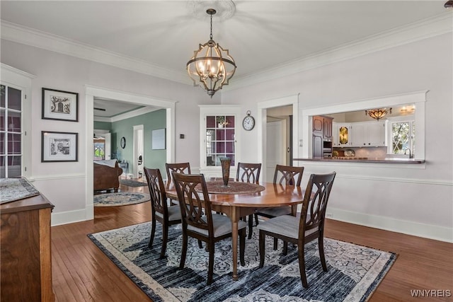 dining room with a chandelier, dark wood-type flooring, ornamental molding, and baseboards