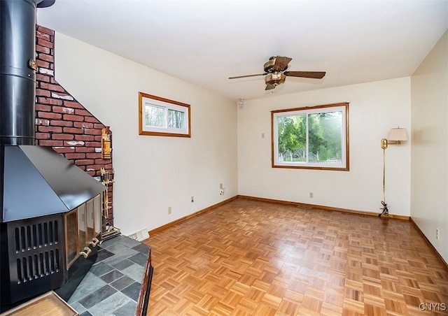 6 Tyler Ct, Manlius, NY 13104 - unfurnished living room featuring a ceiling fan, baseboards, and a wood stove