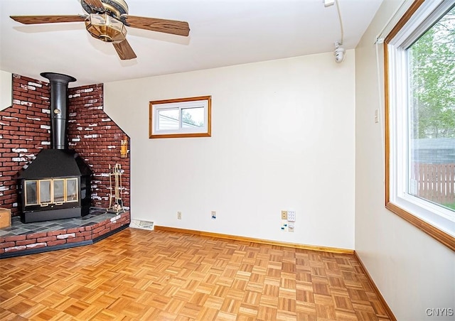 6 Tyler Ct, Manlius, NY 13104 - unfurnished living room featuring baseboards, a wood stove, and ceiling fan