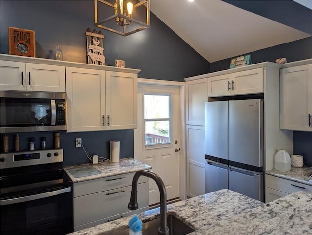 5 S Hartland St, Royalton, NY 14105 - kitchen with stainless steel appliances, vaulted ceiling, white cabinetry, and light stone countertops