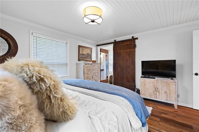 bedroom featuring crown molding, wood-type flooring, a barn door, and baseboards