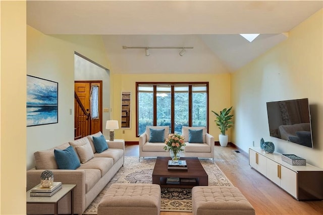 48 Hemlock Ln, Erwin, NY 14870 - living area with track lighting, light wood finished floors, lofted ceiling, a skylight, and stairway