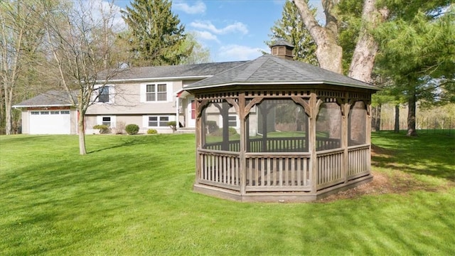 view of green lawn with a gazebo and a garage