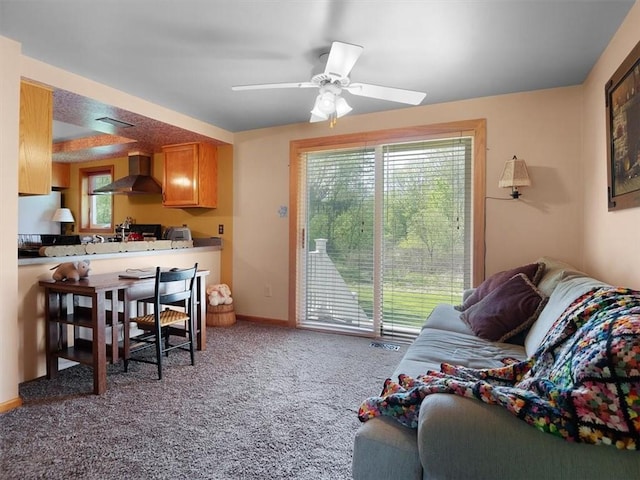 living room with light colored carpet, a ceiling fan, and baseboards