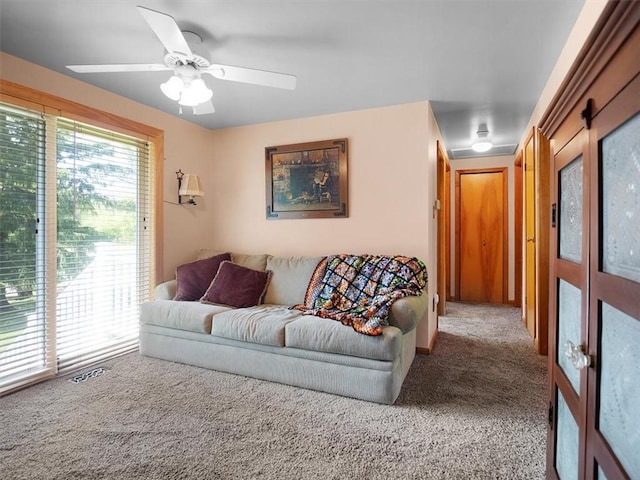 carpeted living area featuring ceiling fan