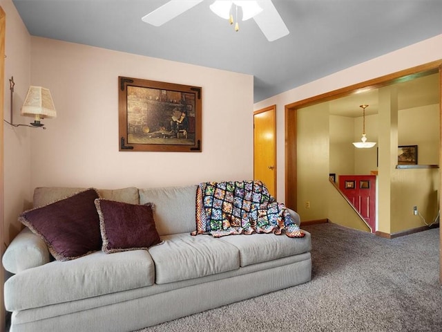 carpeted living area featuring ceiling fan and baseboards