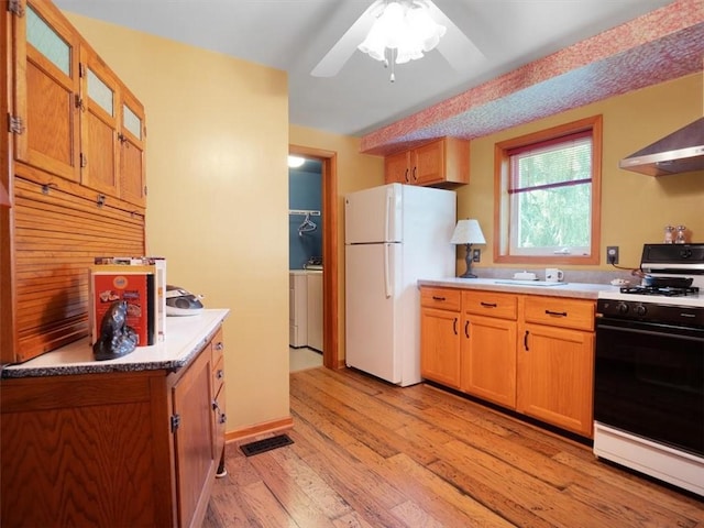 kitchen featuring gas stove, freestanding refrigerator, light wood-style floors, a ceiling fan, and light countertops