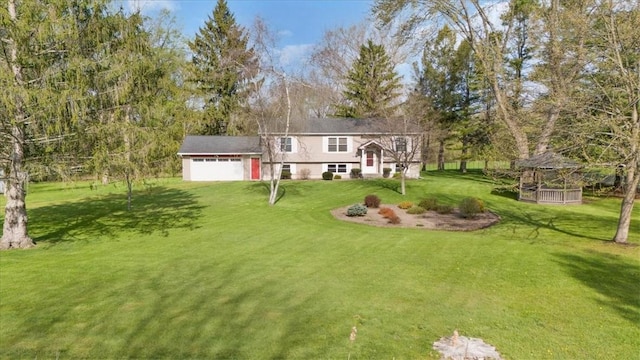 view of grassy yard with a gazebo, a garage, and driveway