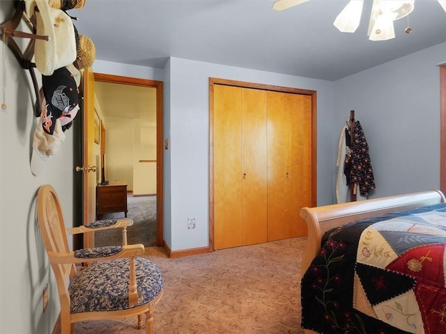 carpeted bedroom featuring a closet, baseboards, and ceiling fan