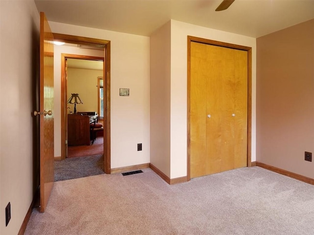 unfurnished bedroom featuring carpet flooring, baseboards, and a closet