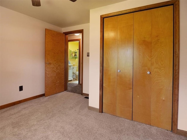 unfurnished bedroom with carpet floors, a closet, baseboards, and ceiling fan