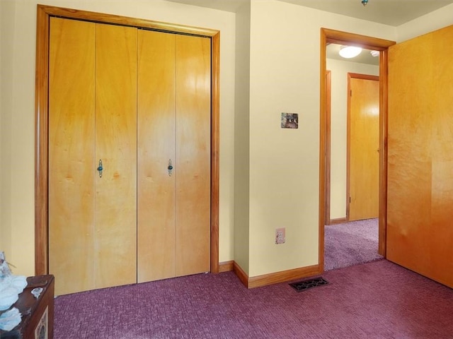 unfurnished bedroom featuring carpet flooring, a closet, and baseboards