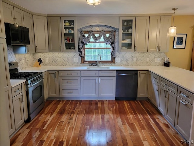 3130 Meadow View Ln, Sennett, NY 13021 - kitchen with appliances with stainless steel finishes, a sink, dark wood finished floors, light countertops, and backsplash