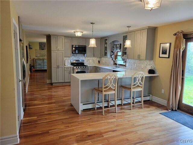 3130 Meadow View Ln, Sennett, NY 13021 - kitchen featuring appliances with stainless steel finishes, gray cabinetry, a baseboard heating unit, a sink, and a peninsula