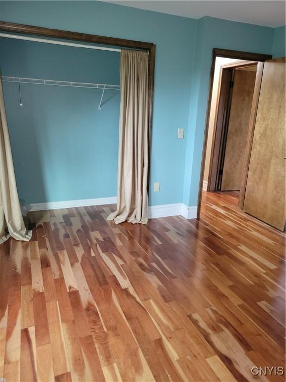 3130 Meadow View Ln, Sennett, NY 13021 - unfurnished bedroom featuring wood finished floors, a closet, and baseboards