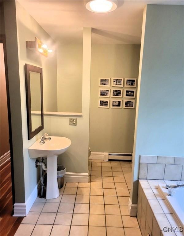 3130 Meadow View Ln, Sennett, NY 13021 - bathroom with a baseboard heating unit, baseboards, tile patterned flooring, tiled tub, and toilet
