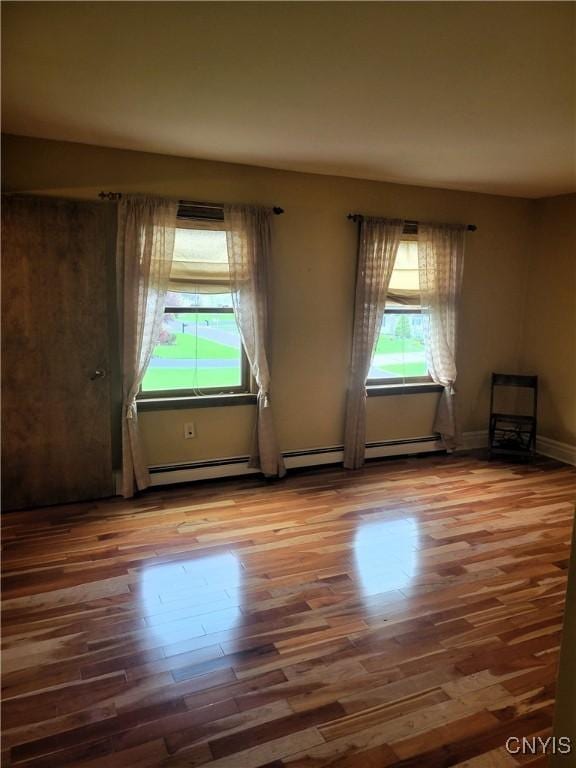 3130 Meadow View Ln, Sennett, NY 13021 - unfurnished room featuring healthy amount of natural light, a baseboard heating unit, wood finished floors, and baseboards