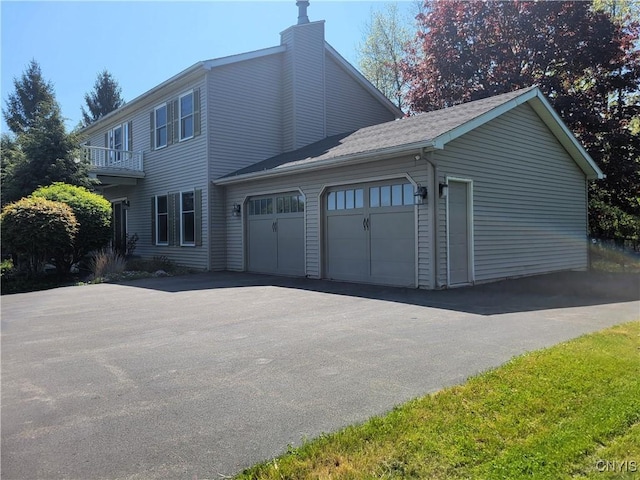3130 Meadow View Ln, Sennett, NY 13021 - view of front facade with a chimney, an attached garage, a balcony, and asphalt driveway