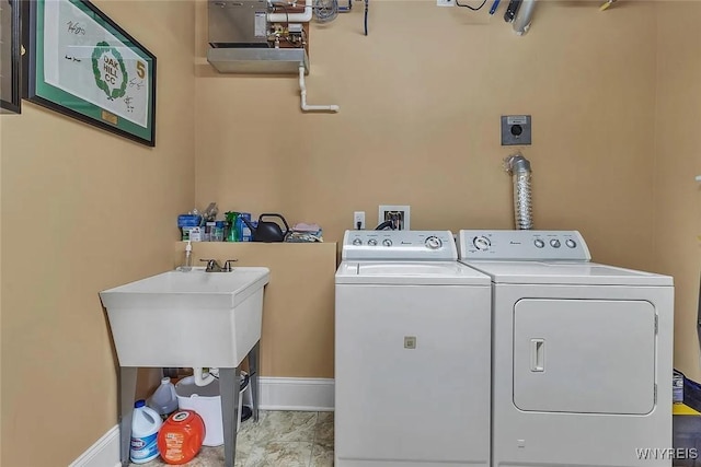 laundry area with washing machine and dryer and baseboards