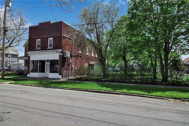 view of front of home with brick siding and a front lawn
