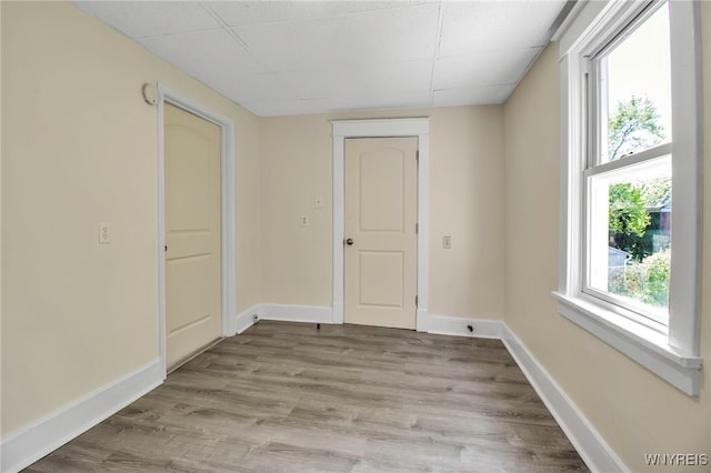 spare room featuring baseboards and wood finished floors