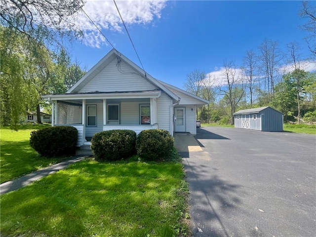 43 Canal St, Big Flats, NY 14814 - view of front of home with an outdoor structure, a front yard, covered porch, and a shed