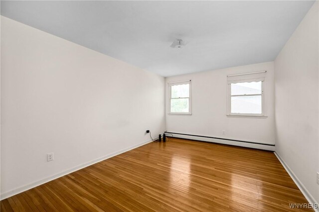 187 Dan Troy Dr, Amherst, NY 14221 - empty room featuring a baseboard heating unit, wood finished floors, and baseboards