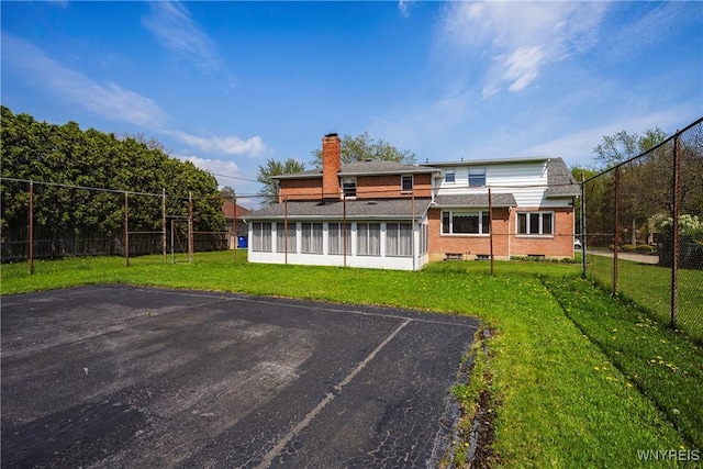 187 Dan Troy Dr, Amherst, NY 14221 - rear view of house with a sunroom, a chimney, and uncovered parking