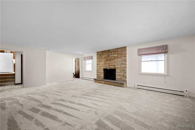 187 Dan Troy Dr, Amherst, NY 14221 - unfurnished living room with a baseboard heating unit, carpet flooring, a stone fireplace, baseboards, and crown molding