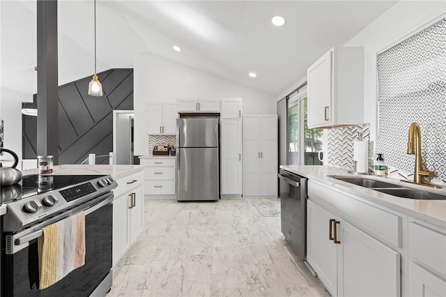 35 Squire Cir, Penfield, NY 14526 - kitchen featuring appliances with stainless steel finishes, a sink, vaulted ceiling, white cabinetry, and tasteful backsplash