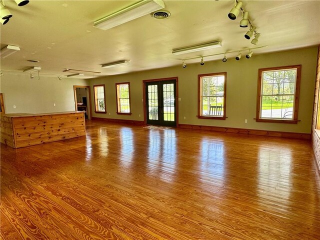 225 John Cook Rd, Unadilla, NY 13849 - unfurnished living room with wood finished floors, plenty of natural light, track lighting, and baseboards