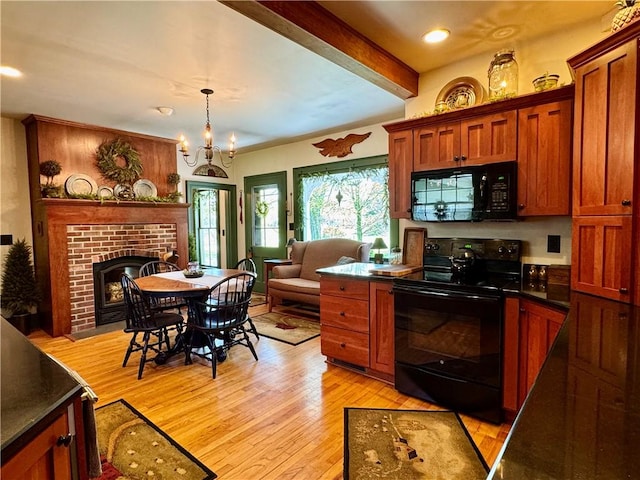 225 John Cook Rd, Unadilla, NY 13849 - kitchen featuring black appliances, dark countertops, light wood-style flooring, brown cabinets, and a brick fireplace