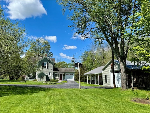 225 John Cook Rd, Unadilla, NY 13849 - view of front of property with a garage, a front lawn, asphalt driveway, and an outdoor structure