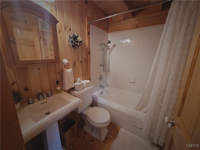 177 Woodchuck Run, Jefferson, NY 12093 - bathroom featuring shower / bath combo, toilet, wooden walls, and wood finished floors