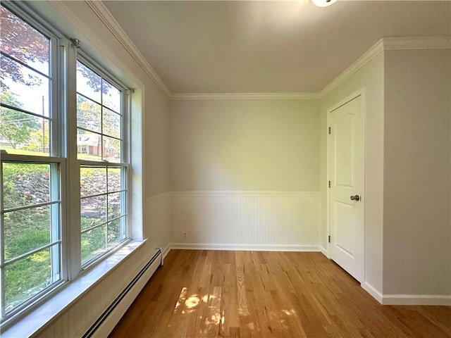 5 Orchard Dr, Corning, NY 14830 - empty room with a baseboard heating unit, healthy amount of natural light, wood finished floors, a wainscoted wall, and ornamental molding