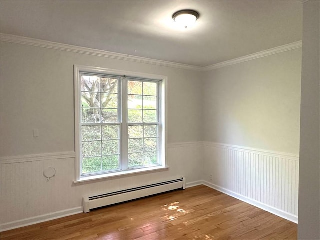 5 Orchard Dr, Corning, NY 14830 - empty room featuring baseboard heating, plenty of natural light, wood finished floors, wainscoting, and ornamental molding