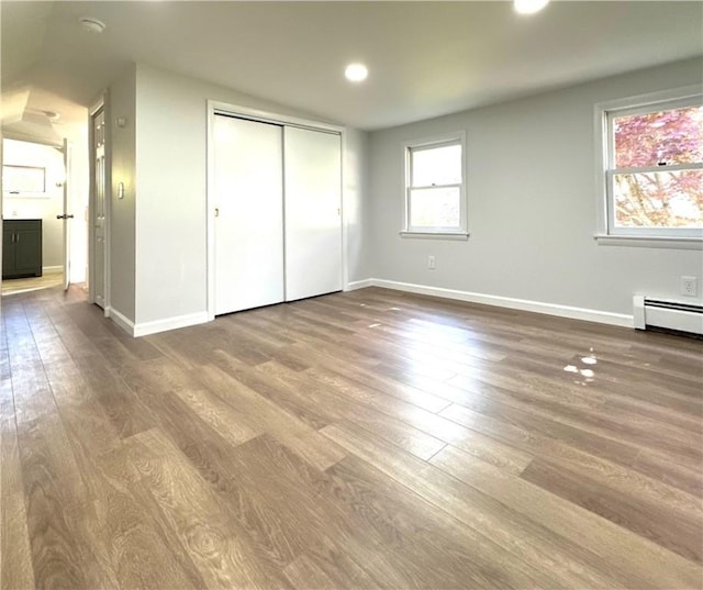 5 Orchard Dr, Corning, NY 14830 - unfurnished bedroom featuring wood finished floors, baseboards, baseboard heating, a closet, and recessed lighting