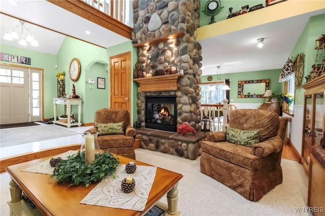 233 Falls Rd, Aurora, NY 14170 - living room with a stone fireplace, vaulted ceiling, baseboards, and arched walkways