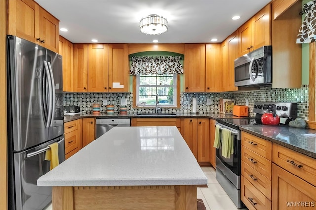 233 Falls Rd, Aurora, NY 14170 - kitchen featuring stainless steel appliances, a sink, dark stone countertops, a kitchen island, and backsplash