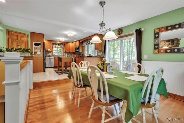 233 Falls Rd, Aurora, NY 14170 - dining space with wainscoting and light wood-style floors