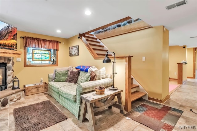 233 Falls Rd, Aurora, NY 14170 - tiled living room featuring stairs, a stone fireplace, and recessed lighting