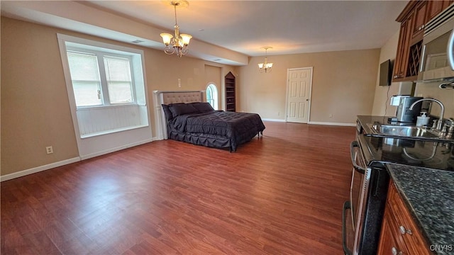 24 Grover St, Auburn, NY 13021 - bedroom with a chandelier, a sink, baseboards, and dark wood-style flooring
