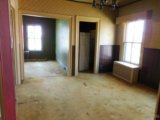 26 Robinson St, Hanover, NY 14136 - unfurnished room with wallpapered walls, a chandelier, wainscoting, radiator, and carpet flooring