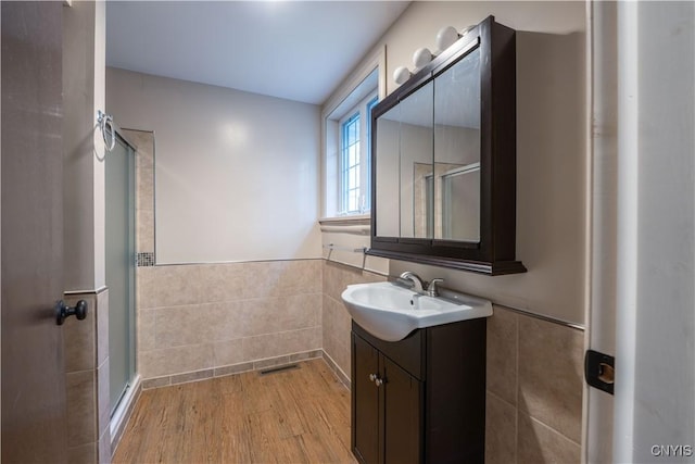 2795 State Route 12b, Marshall, NY 13328 - bathroom featuring tile walls, a shower stall, vanity, a wainscoted wall, and wood finished floors