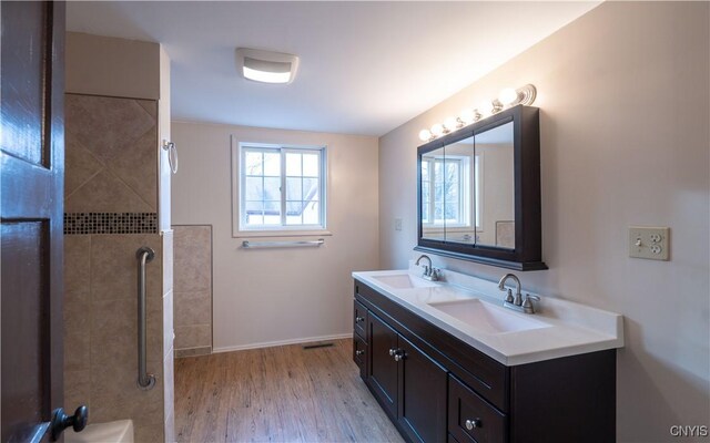 2795 State Route 12b, Marshall, NY 13328 - bathroom featuring tiled shower, wood finished floors, double vanity, and baseboards